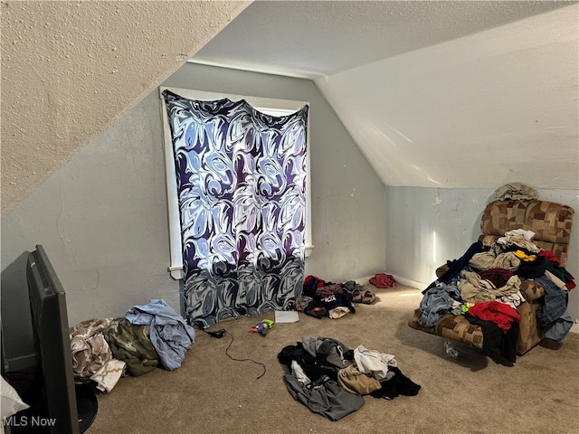 bonus room with a textured ceiling, carpet flooring, and lofted ceiling