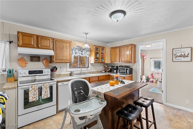 kitchen featuring sink, white range with electric cooktop, decorative light fixtures, and plenty of natural light