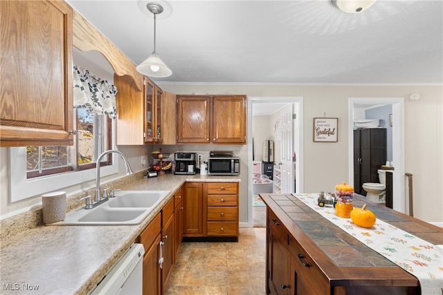 kitchen with dishwasher, sink, hanging light fixtures, and crown molding