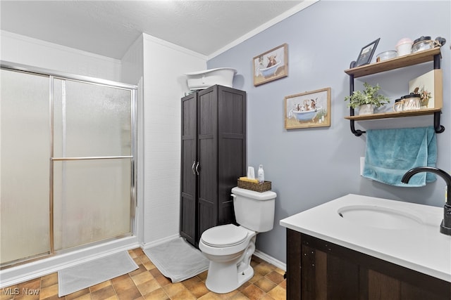 bathroom with vanity, crown molding, toilet, and walk in shower