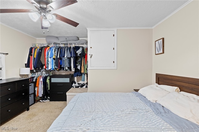 carpeted bedroom with crown molding, a textured ceiling, a closet, and ceiling fan