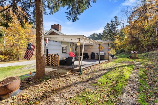 rear view of property featuring a wooden deck