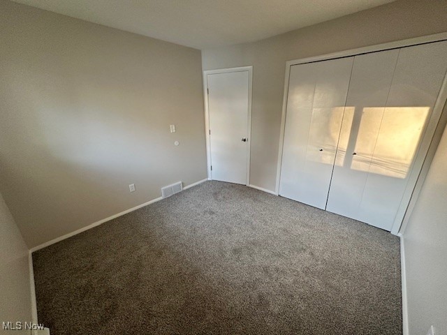 unfurnished bedroom featuring carpet flooring and a closet