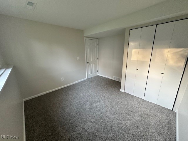 unfurnished bedroom with a closet and carpet flooring