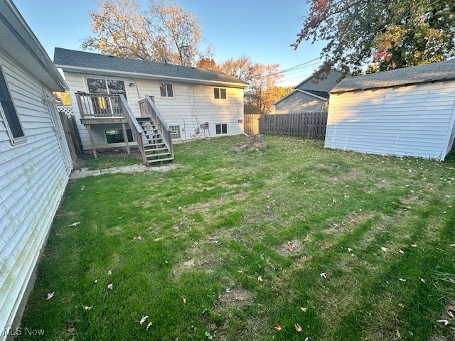 back of property with a wooden deck and a lawn