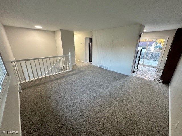 carpeted spare room featuring a textured ceiling