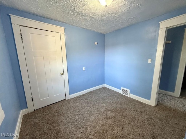 unfurnished bedroom with baseboards, visible vents, and carpet