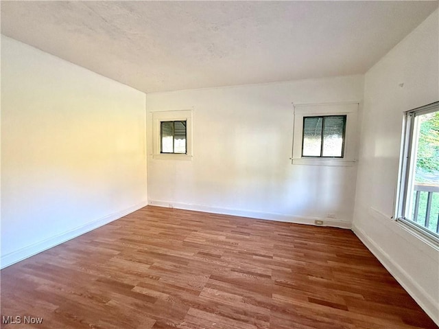 unfurnished room with baseboards and wood finished floors