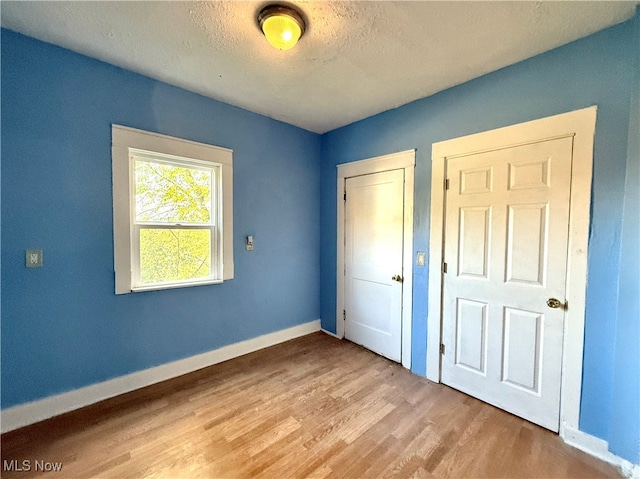 unfurnished bedroom featuring a textured ceiling and light wood-type flooring