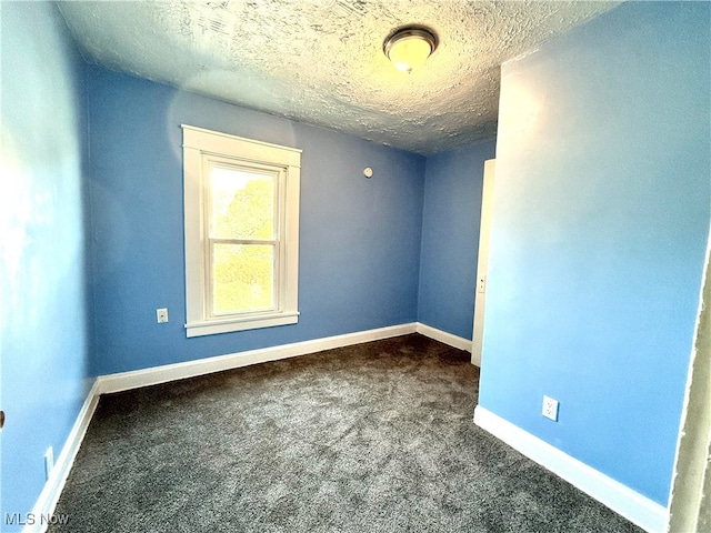 carpeted empty room featuring a textured ceiling