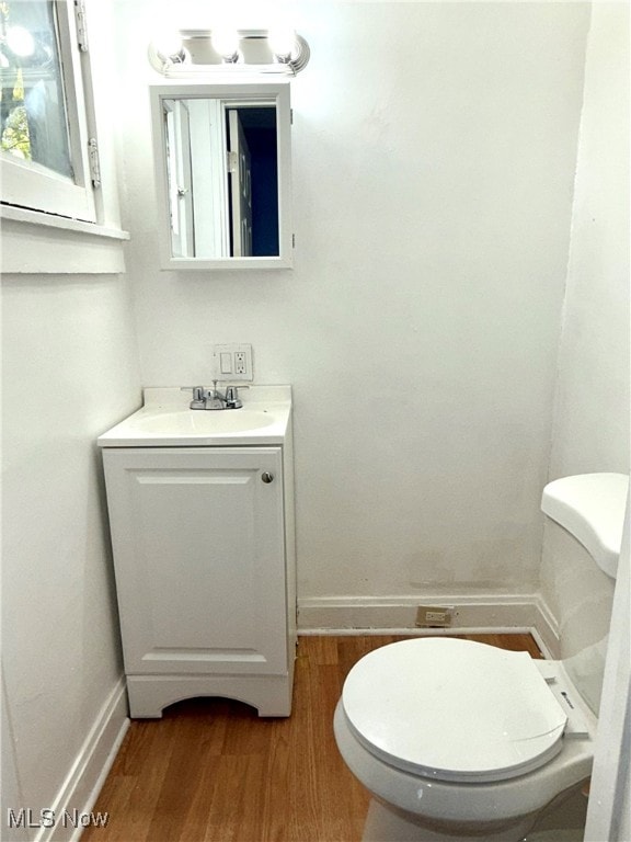 bathroom with vanity, hardwood / wood-style flooring, and toilet