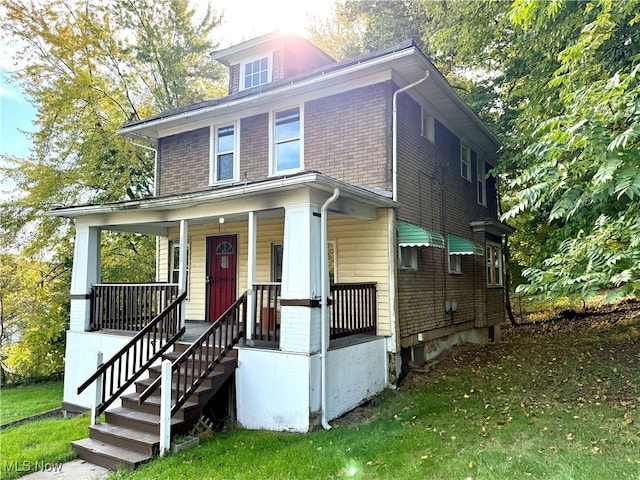 view of front of property with a porch and a front lawn