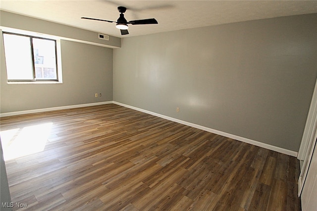 empty room featuring dark wood-type flooring and ceiling fan