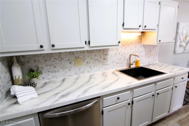 kitchen with dishwasher, decorative backsplash, sink, light wood-type flooring, and white cabinets