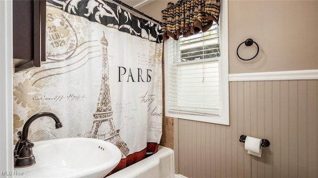 bathroom with shower / tub combo with curtain and sink