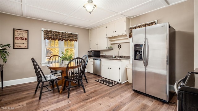 kitchen with light hardwood / wood-style floors, white cabinetry, stainless steel appliances, and sink