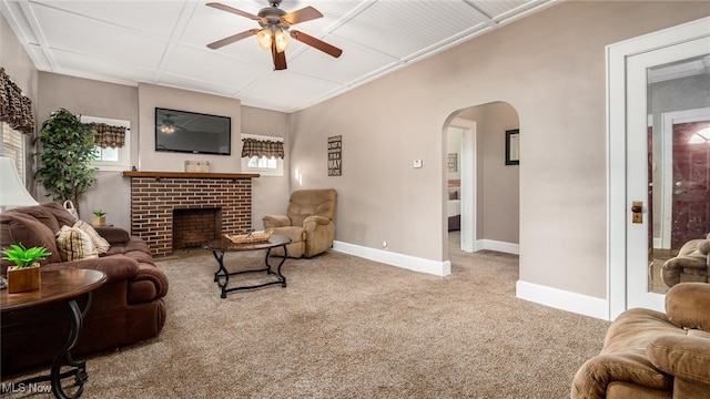 living room featuring carpet floors, a wealth of natural light, a fireplace, and ceiling fan