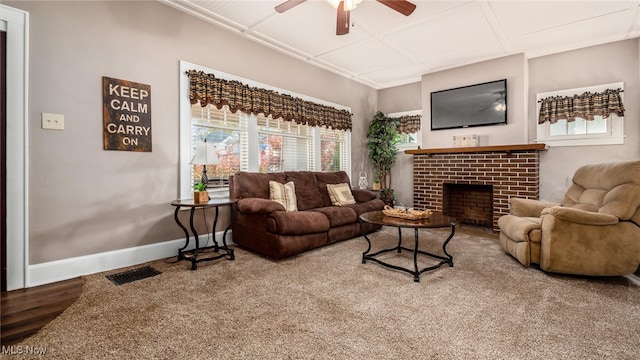 living room with ceiling fan, wood-type flooring, and a brick fireplace