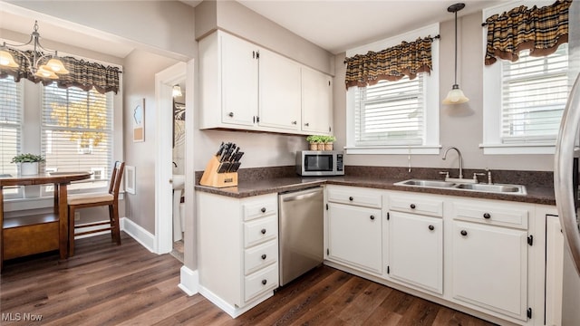 kitchen with a healthy amount of sunlight, appliances with stainless steel finishes, dark hardwood / wood-style floors, and white cabinets