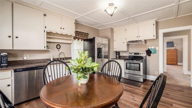 kitchen with white cabinetry, appliances with stainless steel finishes, and hardwood / wood-style floors