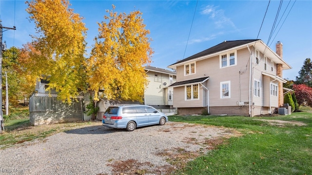 view of front of property featuring a front lawn and central air condition unit