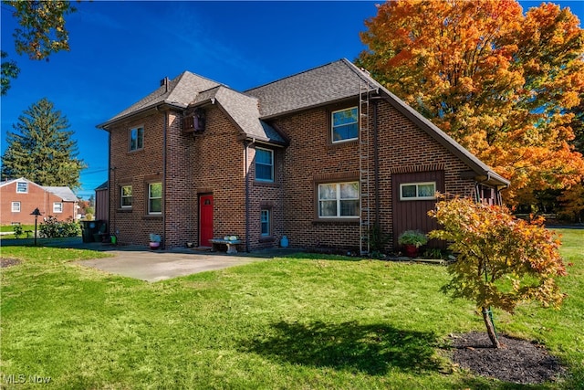 rear view of house with a patio area and a lawn