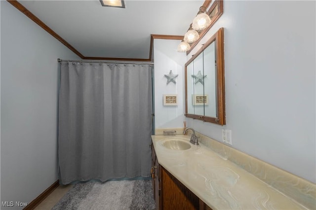 bathroom with vanity, curtained shower, and ornamental molding