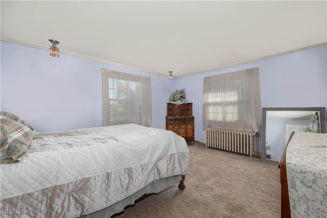 bedroom with radiator heating unit, crown molding, and carpet flooring