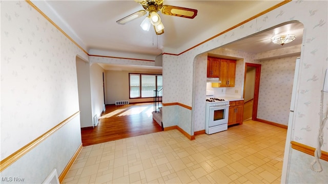 kitchen featuring light hardwood / wood-style floors, ornamental molding, white gas stove, and ceiling fan