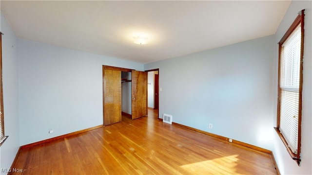 unfurnished bedroom featuring light hardwood / wood-style flooring and a closet