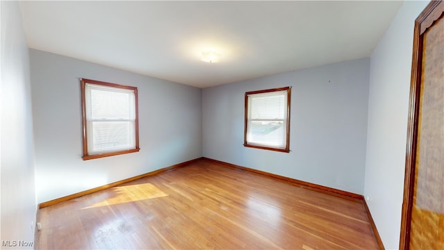 spare room featuring a wealth of natural light and light wood-type flooring