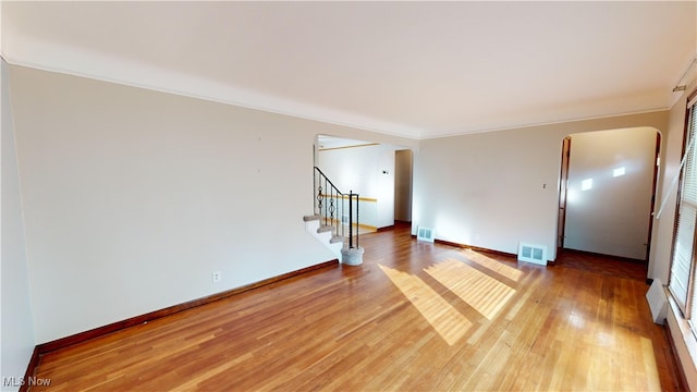 unfurnished room featuring ornamental molding and hardwood / wood-style floors