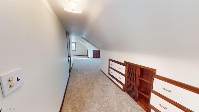 hall featuring light carpet and lofted ceiling