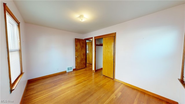 unfurnished bedroom with a closet and light wood-type flooring