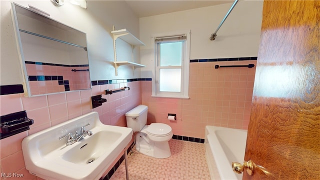 bathroom with toilet, tile walls, sink, and tile patterned flooring