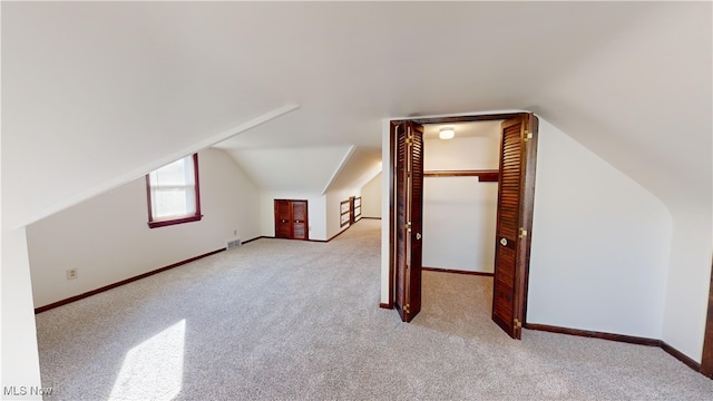 additional living space with lofted ceiling and light colored carpet