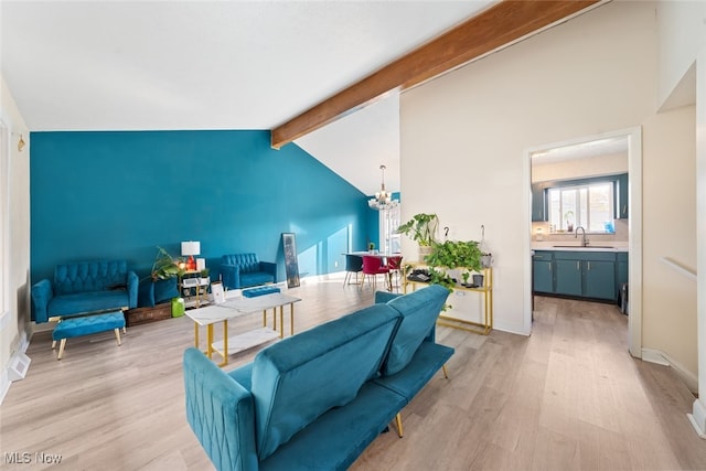 living room with beamed ceiling, light hardwood / wood-style flooring, sink, a notable chandelier, and high vaulted ceiling