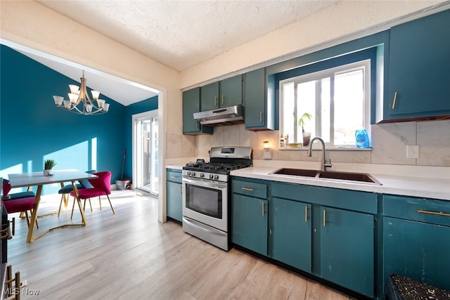 kitchen with sink, a textured ceiling, lofted ceiling, pendant lighting, and stainless steel gas range