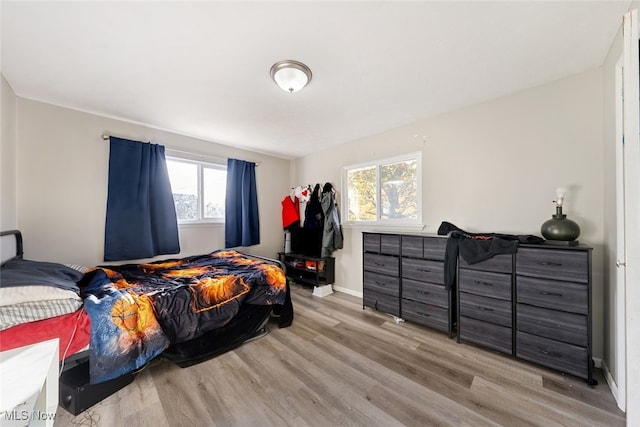 bedroom featuring light hardwood / wood-style flooring and multiple windows