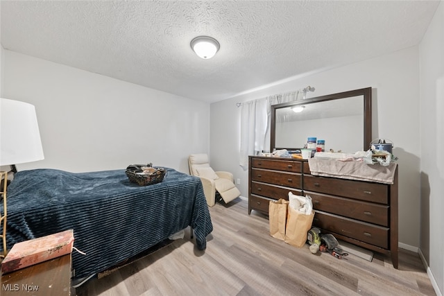 bedroom featuring a textured ceiling and light hardwood / wood-style floors