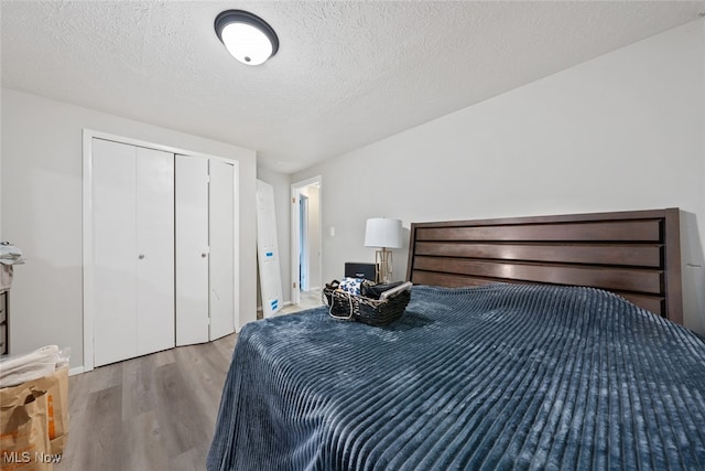 bedroom featuring a closet, a textured ceiling, and light wood-type flooring