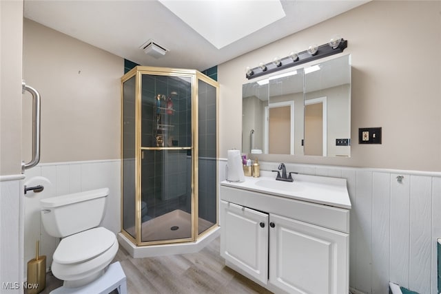 bathroom featuring vanity, toilet, wood-type flooring, and an enclosed shower