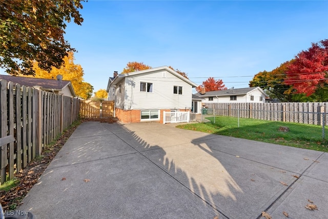 rear view of property with a patio and a lawn