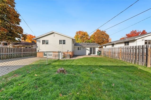 rear view of property with a patio and a lawn