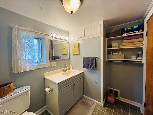 bathroom featuring vanity, toilet, and ornamental molding