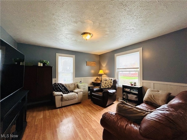 living room featuring a textured ceiling and light hardwood / wood-style flooring