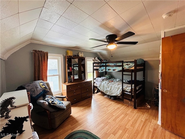 bedroom with ceiling fan, light hardwood / wood-style floors, and vaulted ceiling