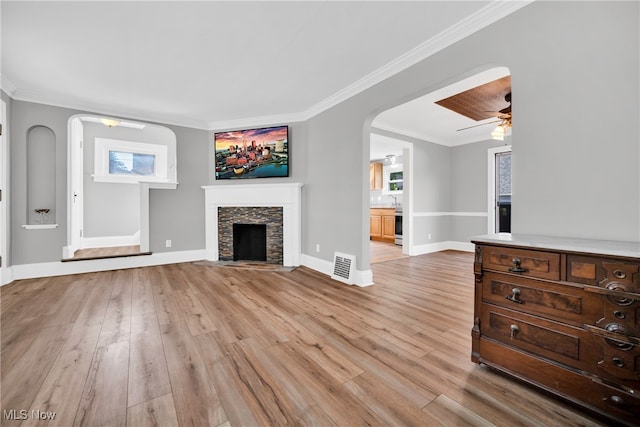 unfurnished living room featuring light hardwood / wood-style floors, crown molding, and a fireplace