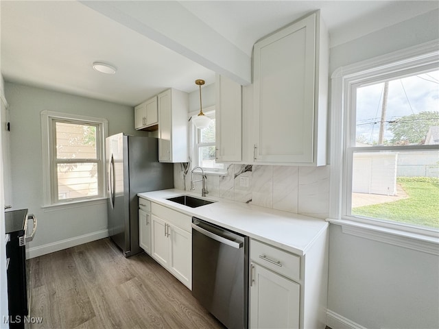 kitchen with sink, appliances with stainless steel finishes, light hardwood / wood-style flooring, and white cabinets