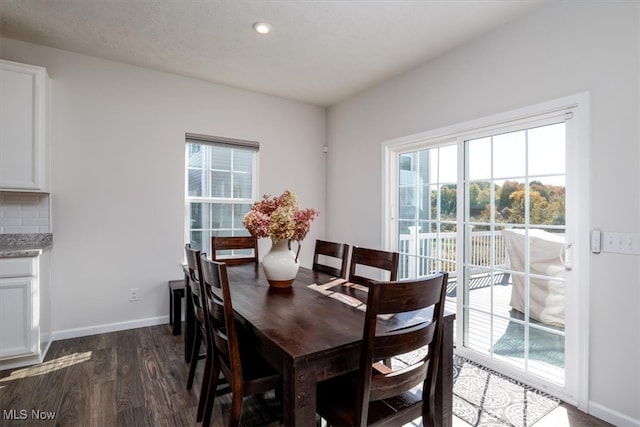 dining space featuring dark wood-type flooring and a textured ceiling